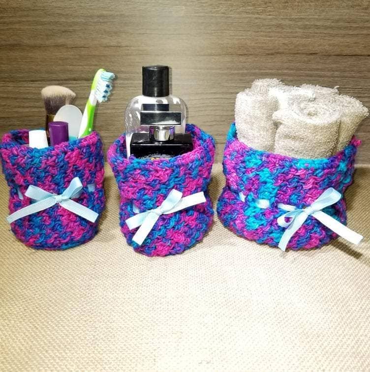 Set of three colorful handmade crochet baskets of varying sizes