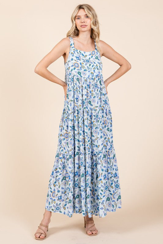 Woman wearing a sleeveless floral print empire waist tiered maxi dress