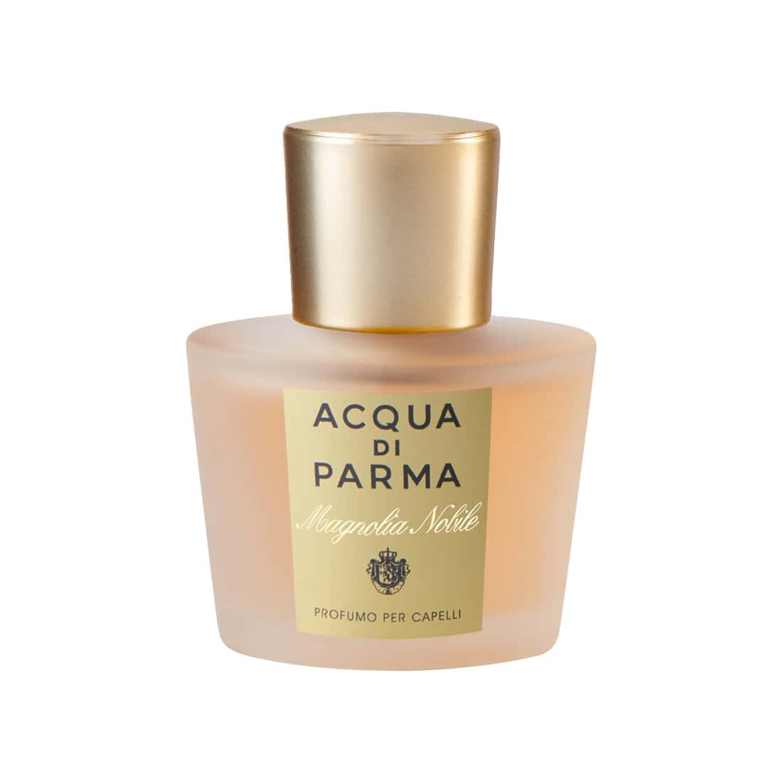 Elegant glass bottle of Acqua di Parma Magnolia Nobile Hair Mist in gold and peach hues.
