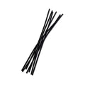 Set of 7 sleek black rattan diffuser reeds arranged in a modern home setting.