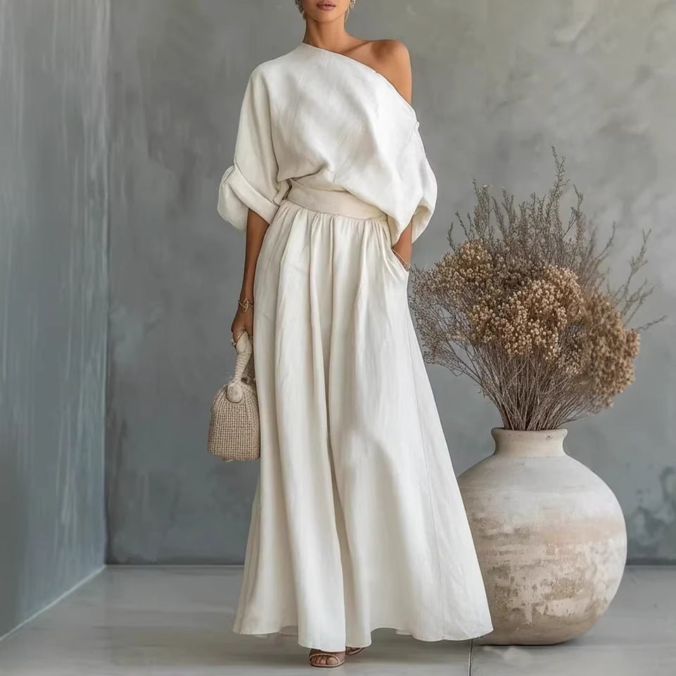 Model wearing a matching two-piece set with an off-shoulder crop top and wide-leg trousers in a neutral color.