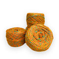 Vibrant marled yarn in citrus orange, bright turquoise, and metallic gold for bohemian craft projects.