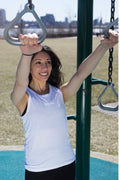 A woman wearing a white Aero Tank top performing agility ladder drills on a field.