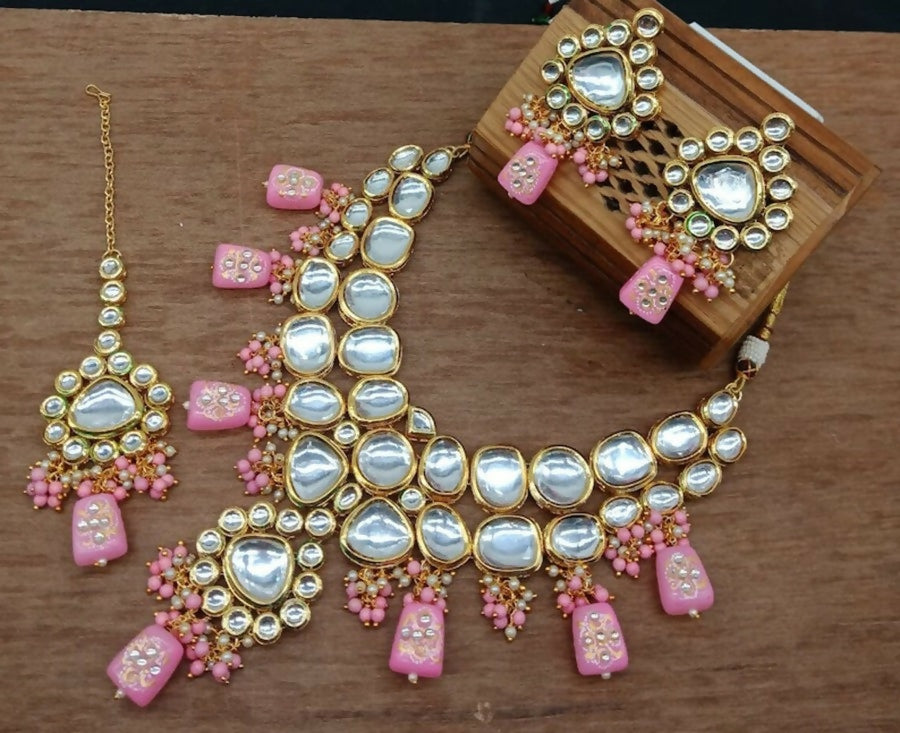 A beautiful baby pink kundan necklace set with gold-plated polish on a clean background