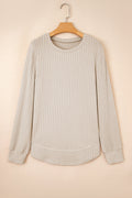 Model wearing a minimalist beige ribbed knit round neck top with high-stretch fabric texture.
