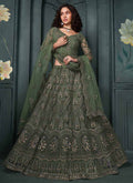 A luxurious mehendi green net bridal lehenga with intricate gold embroidery for traditional Indian wedding ceremonies.