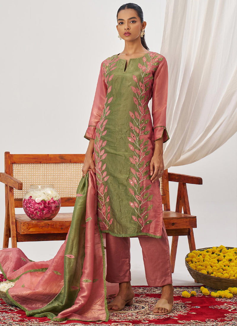 A woman wearing a peach organza embroidered party wear suit with Gota Patti detail