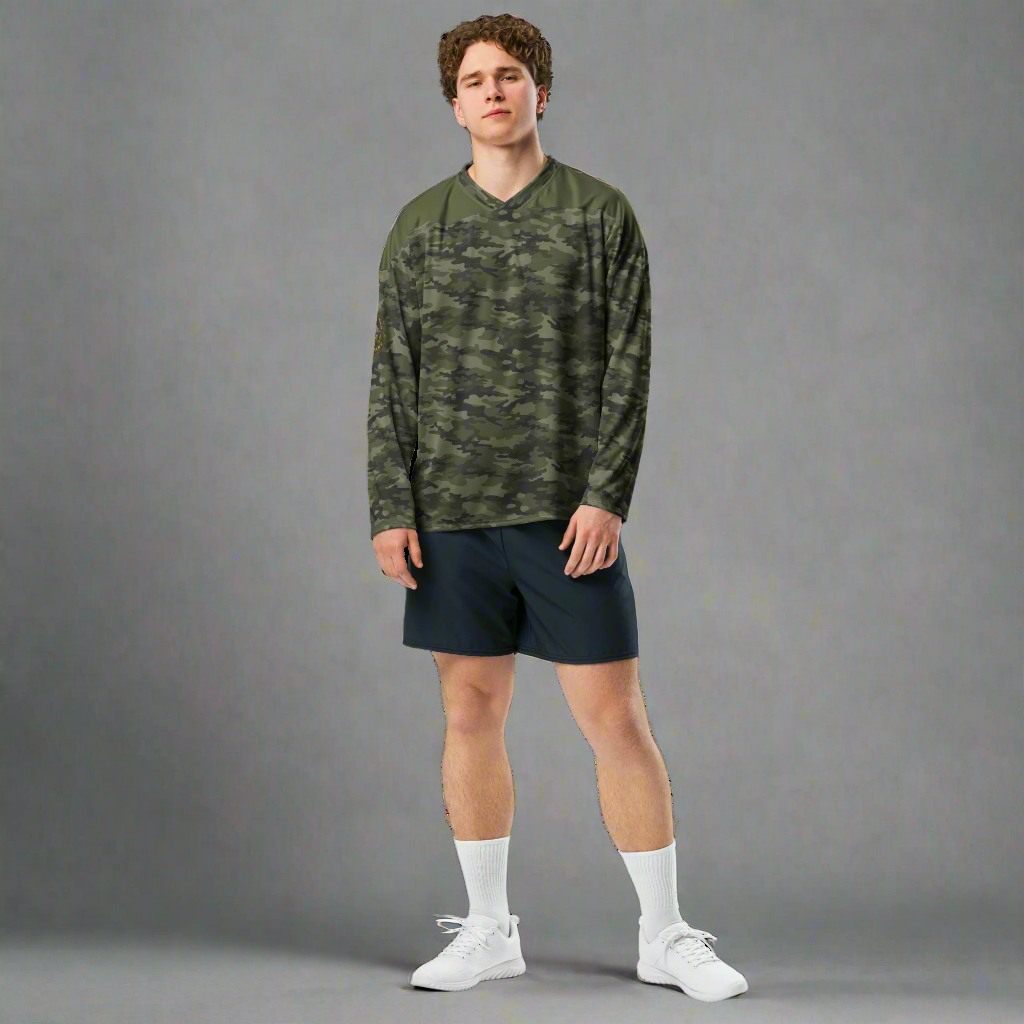 Model wearing a woodland camo long sleeve hockey jersey against a grey background