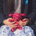 A finished handmade Amigurumi puppy crochet stuffed animal made from yarn.