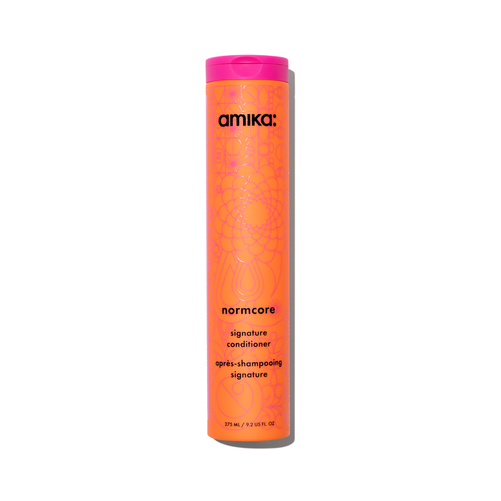 Amika Normcore Signature Conditioner bottle in signature orange and pink packaging