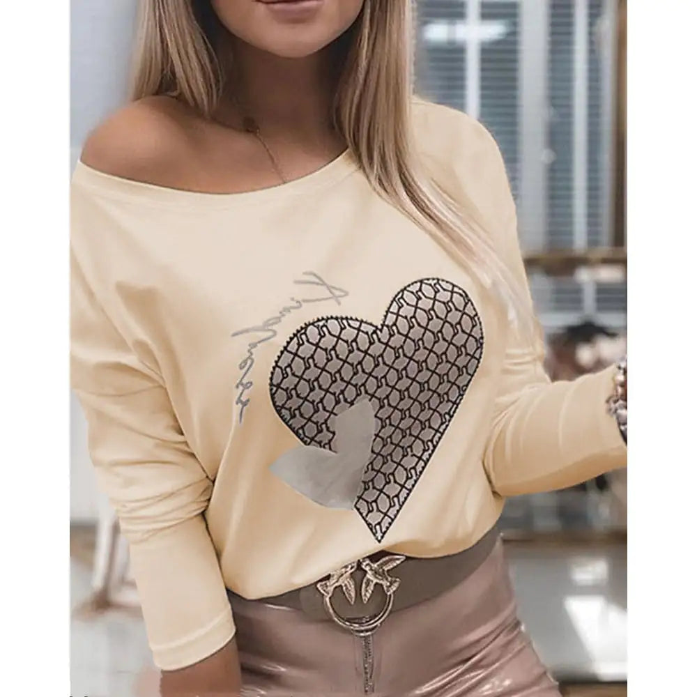 A woman wearing an off-the-shoulder long sleeve blouse with a large heart graphic design.