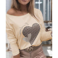 A woman wearing an off-the-shoulder long sleeve blouse with a large heart graphic design.