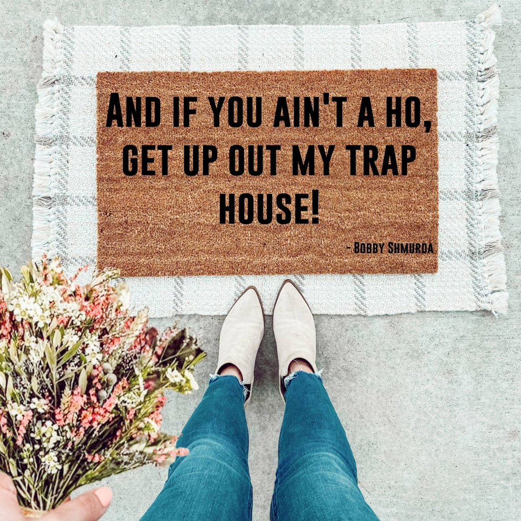 Urban Trap House humorous doormat with brown and black text design on a front porch