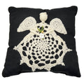 Traditional square throw pillow with angel applique in high-contrast black and cream knit fabric.