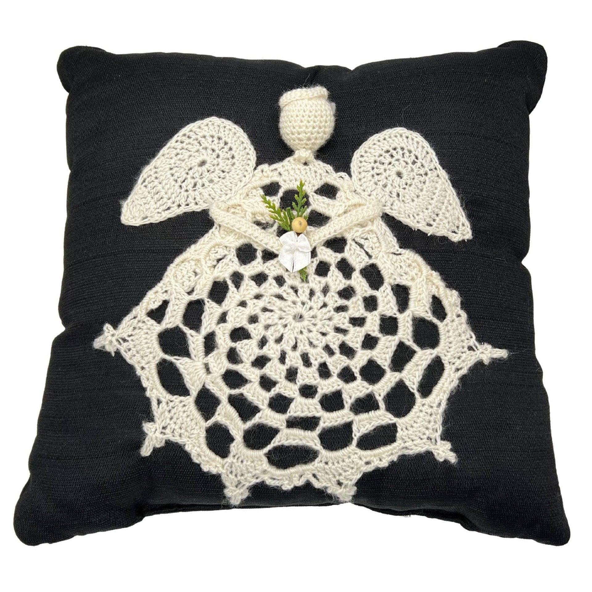 Traditional square throw pillow with angel applique in high-contrast black and cream knit fabric.