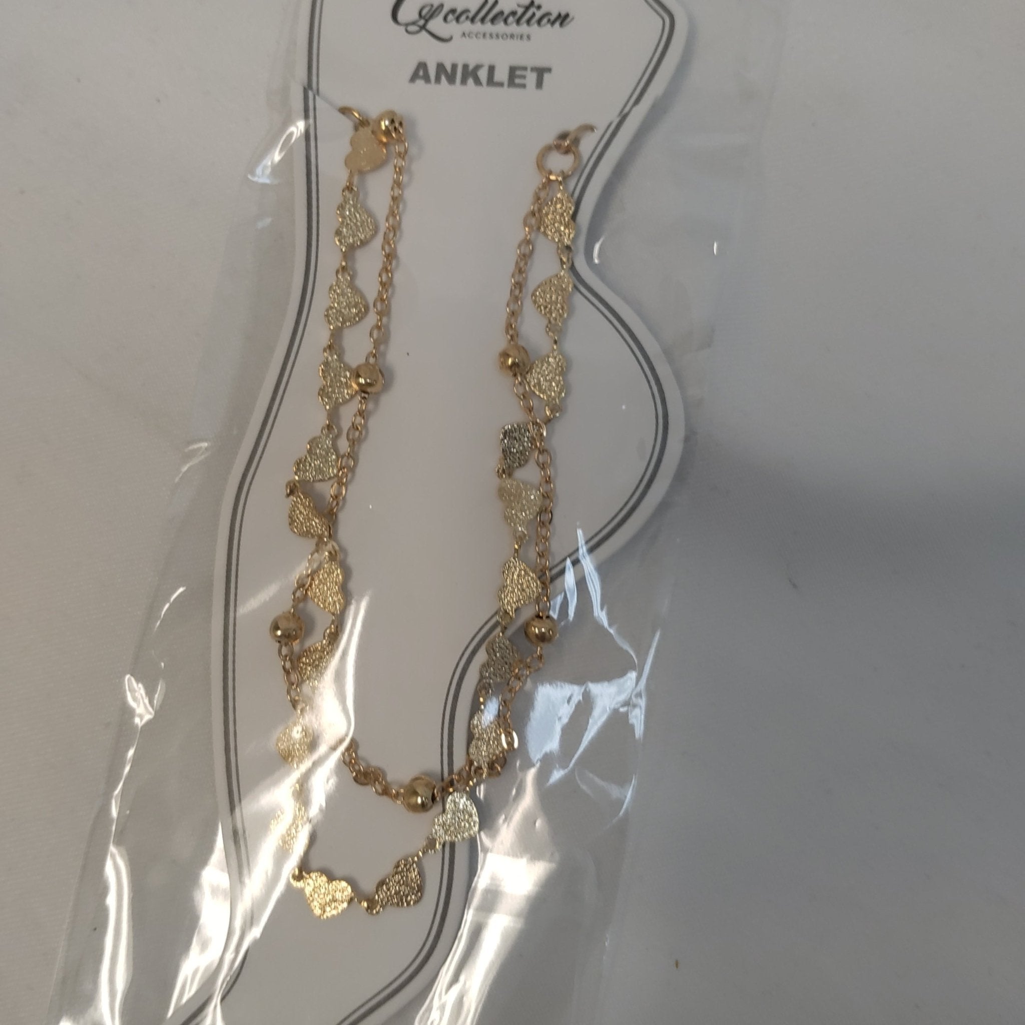 Close up of an elegant, minimalist adjustable anklet worn on a model's ankle.