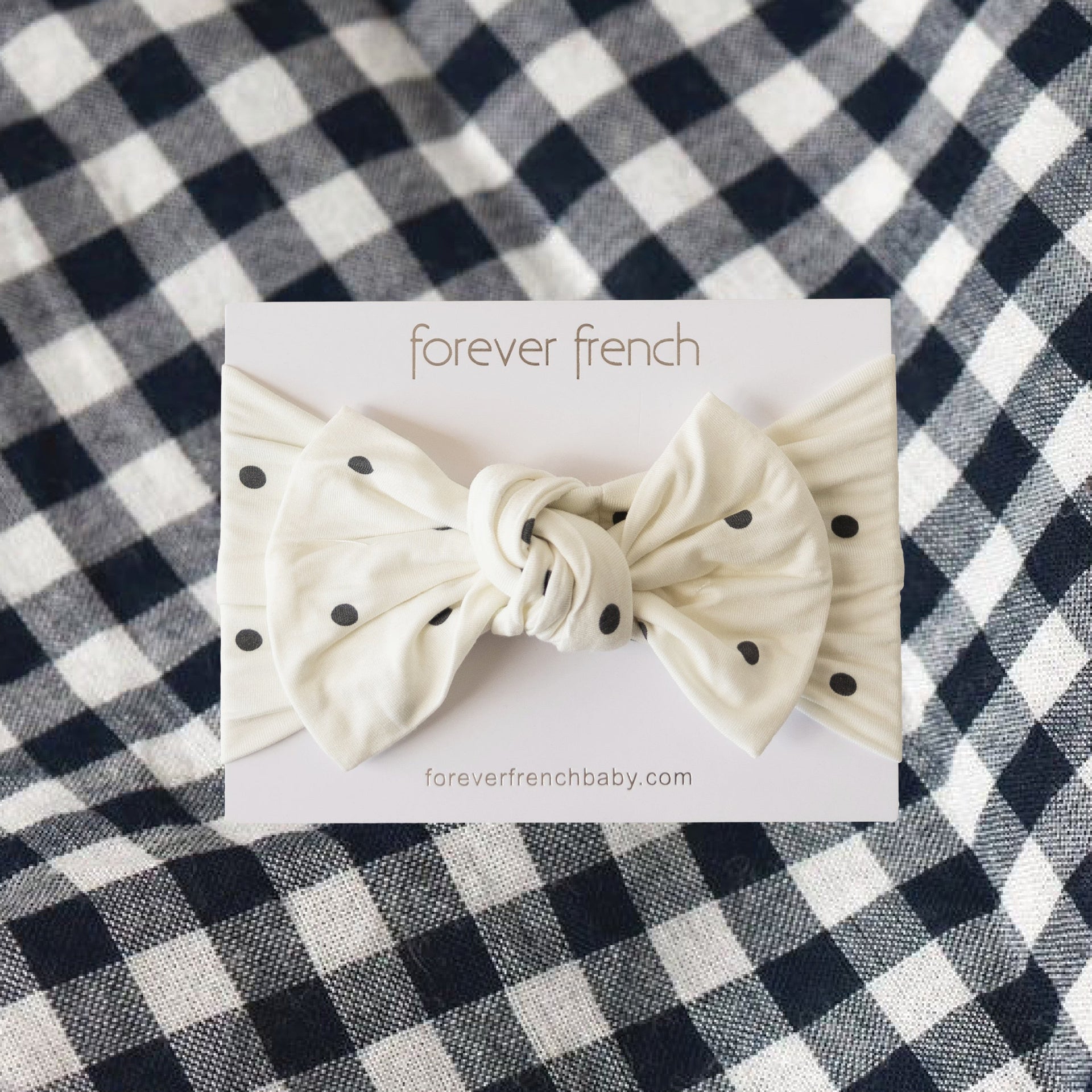 Annie baby head wrap in cream off-white with charcoal black polka dots and a bow