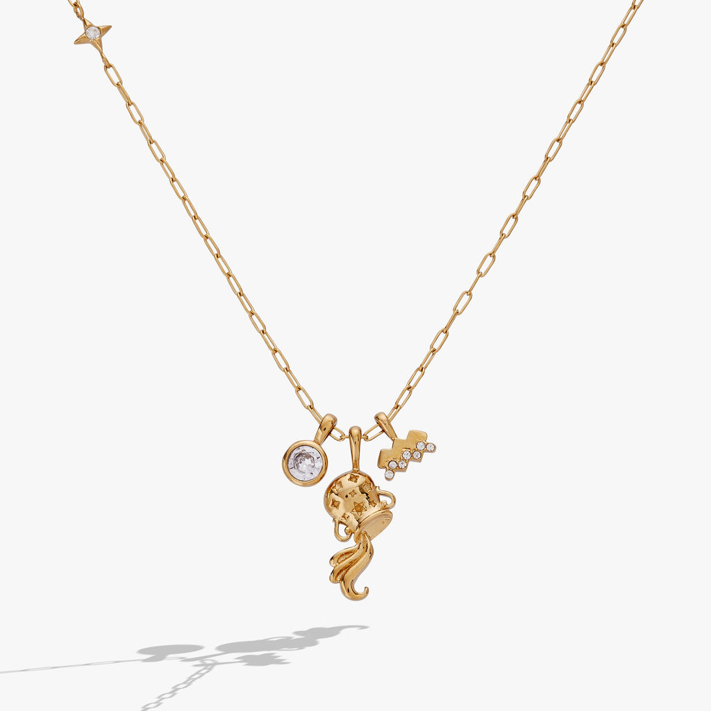 Close up of an Aquarius zodiac charm cluster necklace with crystal pavé on a gold-tone chain.