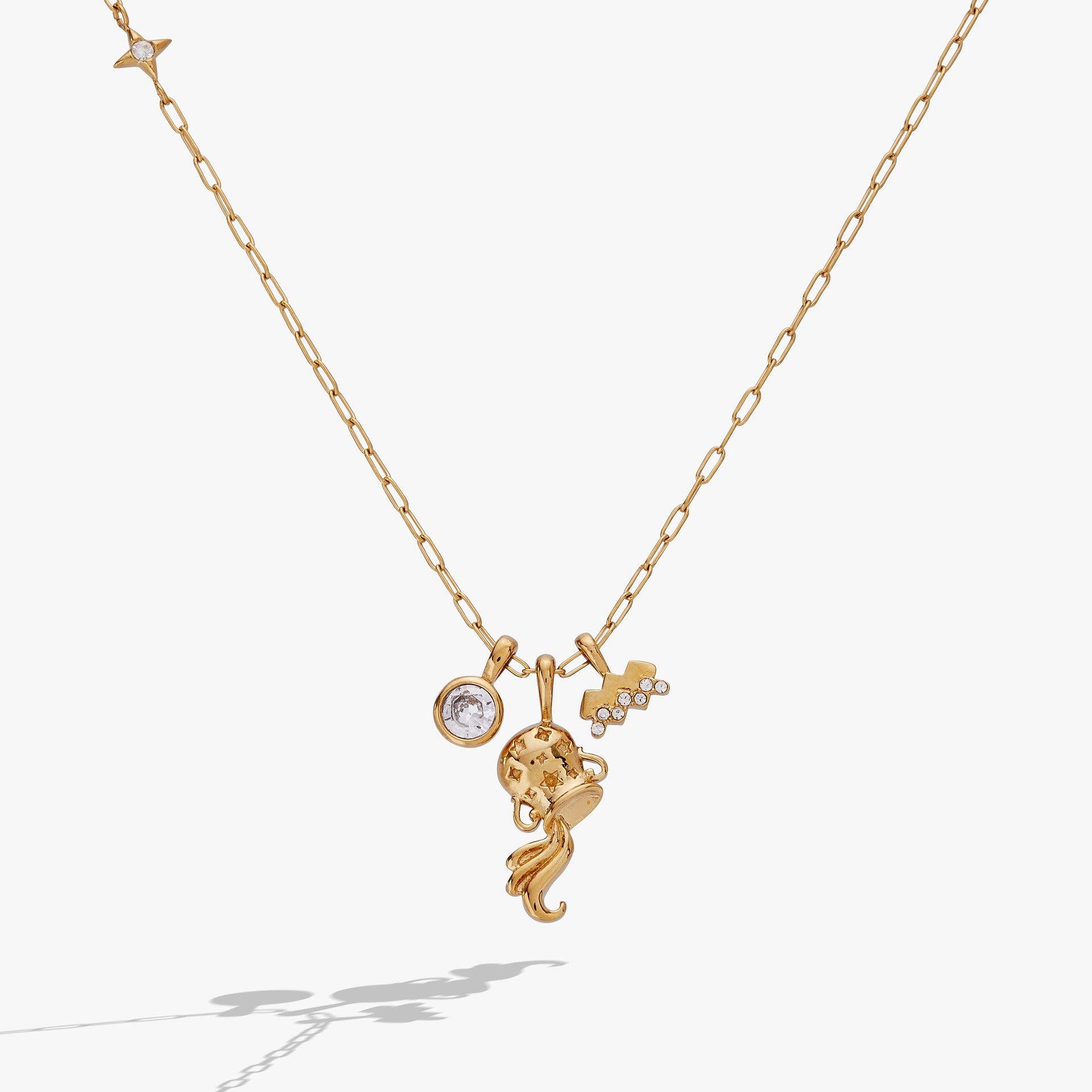 Close up of an Aquarius zodiac charm cluster necklace with crystal pavé on a gold-tone chain.