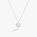 A close-up of a silver Aries zodiac pendant necklace with crystal accents on a cable chain.