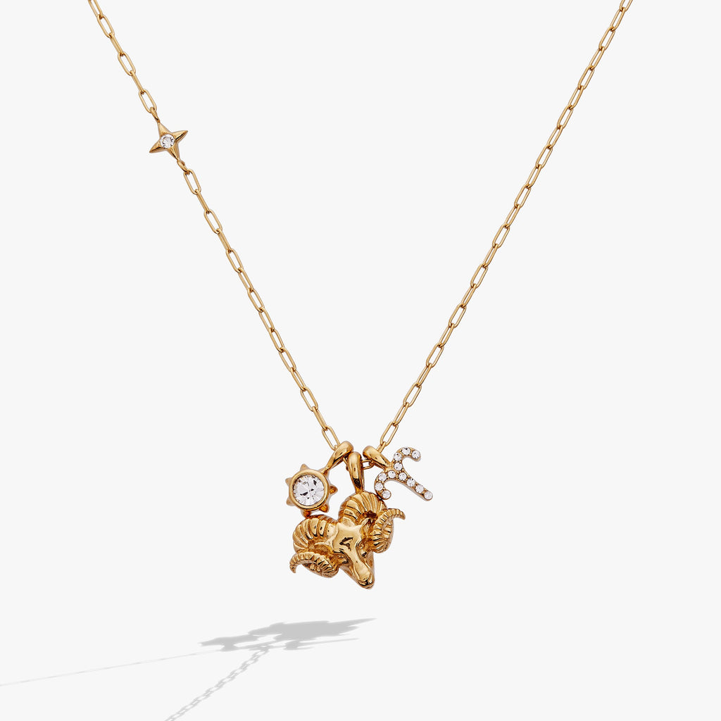 Aries zodiac charm necklace featuring a gold ram, sun crystal, and constellation charms.
