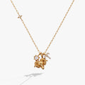 Aries zodiac charm necklace featuring a gold ram, sun crystal, and constellation charms.