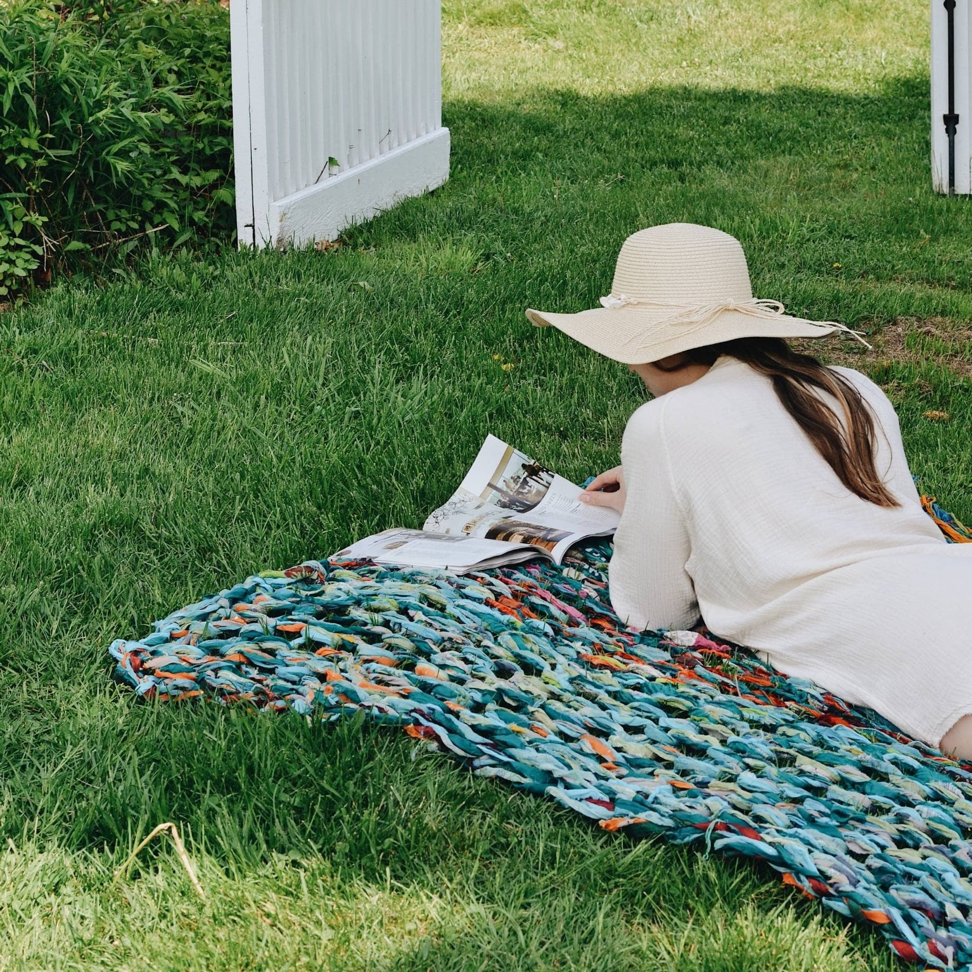 DIY arm knit blanket kit with vibrant teal, aqua, and burnt orange reclaimed chiffon fabric strips.