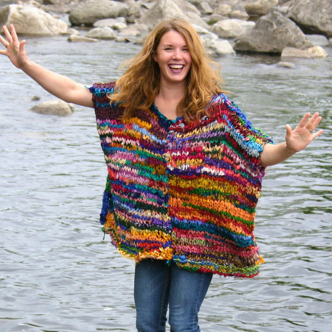 Colorful bohemian-style knit poncho in a rainbow abstract pattern with a relaxed crew neck fit.