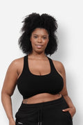 Woman wearing a black low-impact Aspen bra top with a racerback design and scoop neckline.