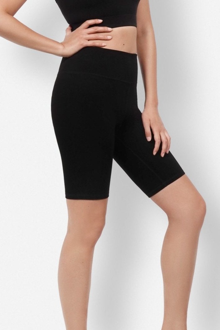 Model wearing high-rise black biker shorts made from soft plant-based fabric