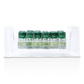 Clear and green bottle of Astera Soothing Freshness Fluid in a minimalist clinical setting