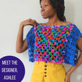 Woman wearing a vibrant multi-color crochet granny square crop top with a square neckline and blue border.