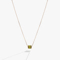 Sliding barrel-shaped pendant necklace featuring peridot-toned green baguette crystals in gold vermeil setting.