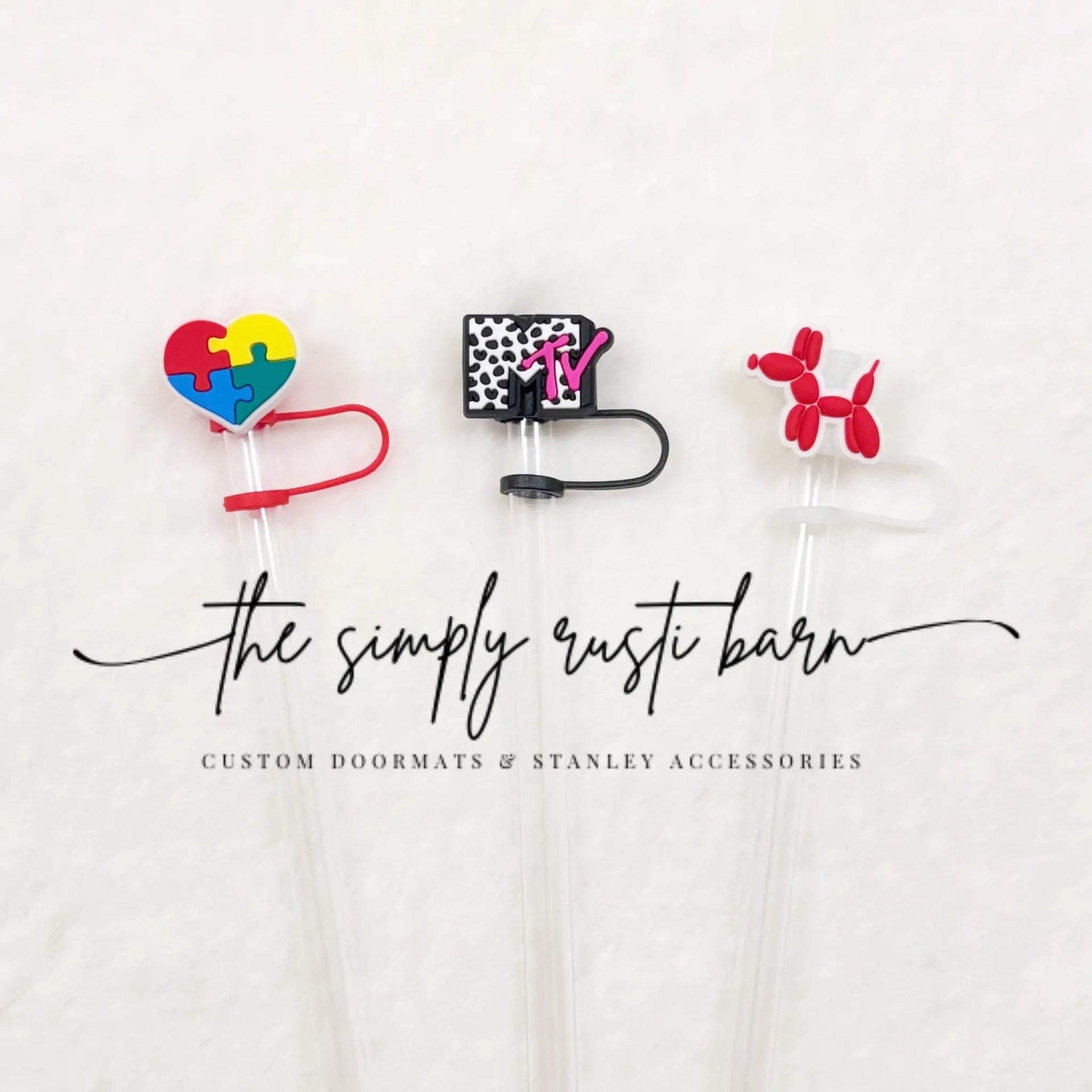 Selection of decorative straw toppers including heart, balloon dog, and letter designs on a Stanley cup straw