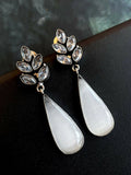 Large white Monalisa stone party earrings in oxidized brass