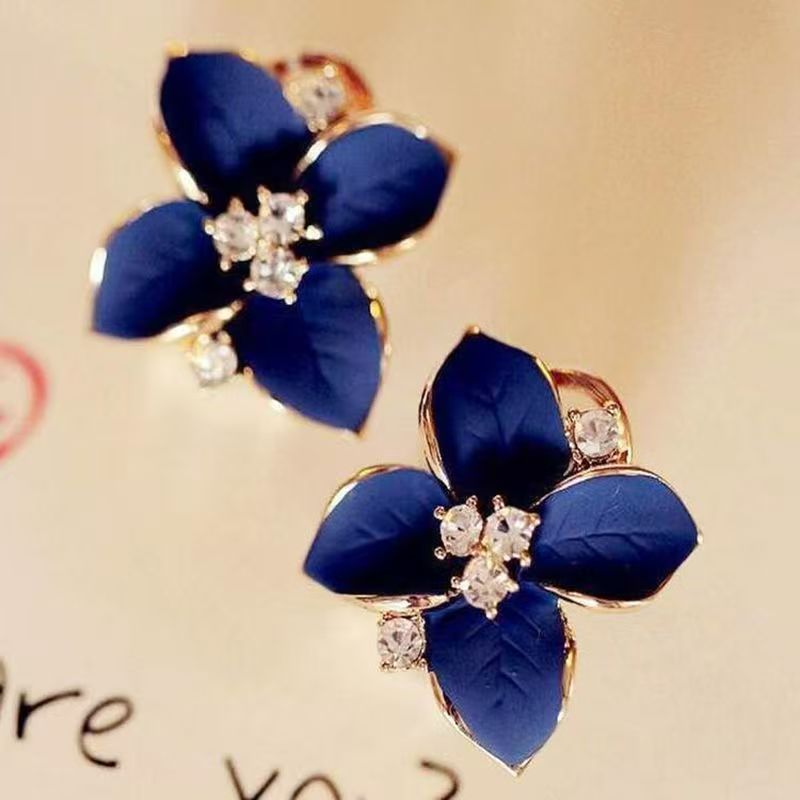 Elegant camellia flower stud earrings featuring clear diamond inlays and polished metal finish.