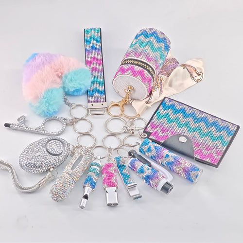 12-piece set of vibrant, glittery suitcase-shaped keychains in various finishes for bags and keys.