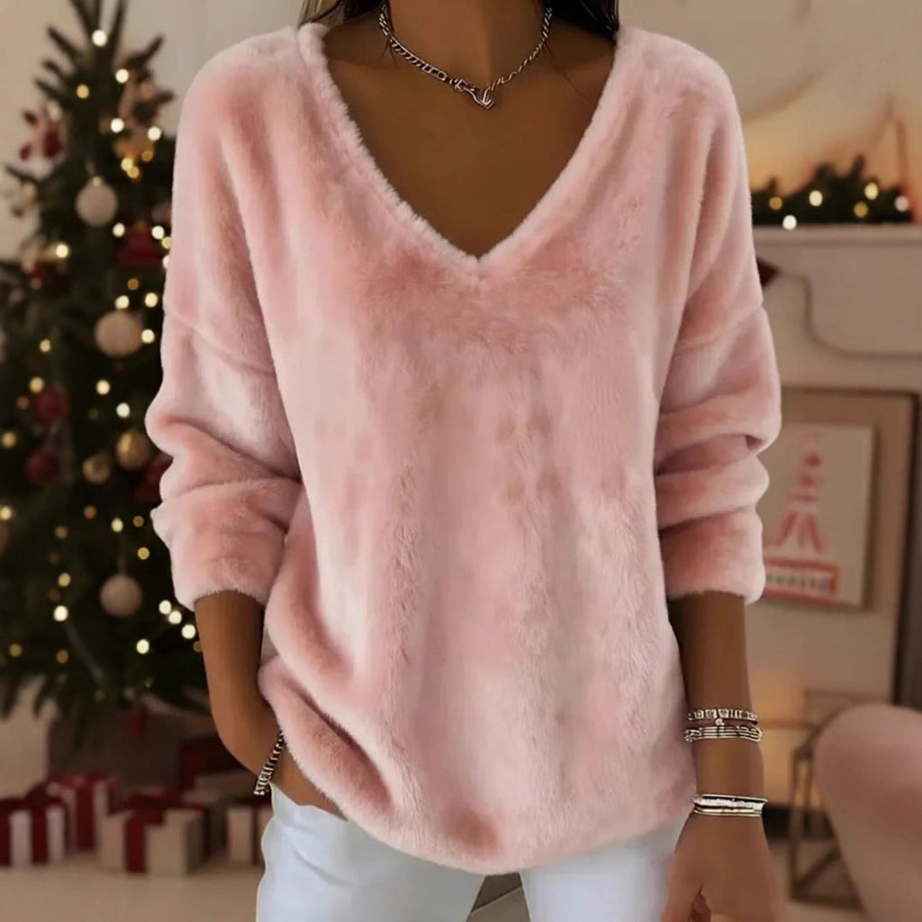 A woman wearing a soft pink plush V-neck pullover sweater with a relaxed drop shoulder fit.