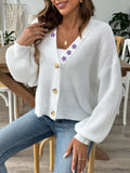 White V-neck button-up cardigan with purple floral embroidery on the shoulder and chest, modeled with jeans.