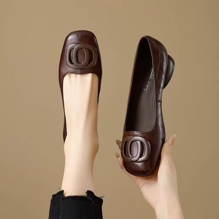 A pair of dark brown slip-on flats with a round toe and low chunky heel