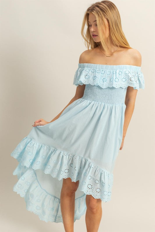 High-low summer dress featuring off-shoulder ruffles and intricate eyelet fabric texture.