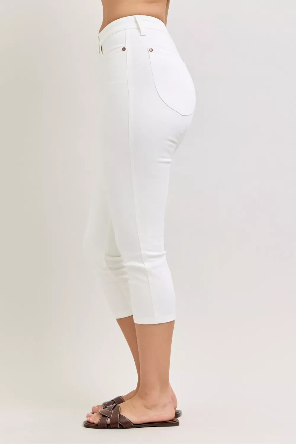 White capri pants worn by a person on a plain background