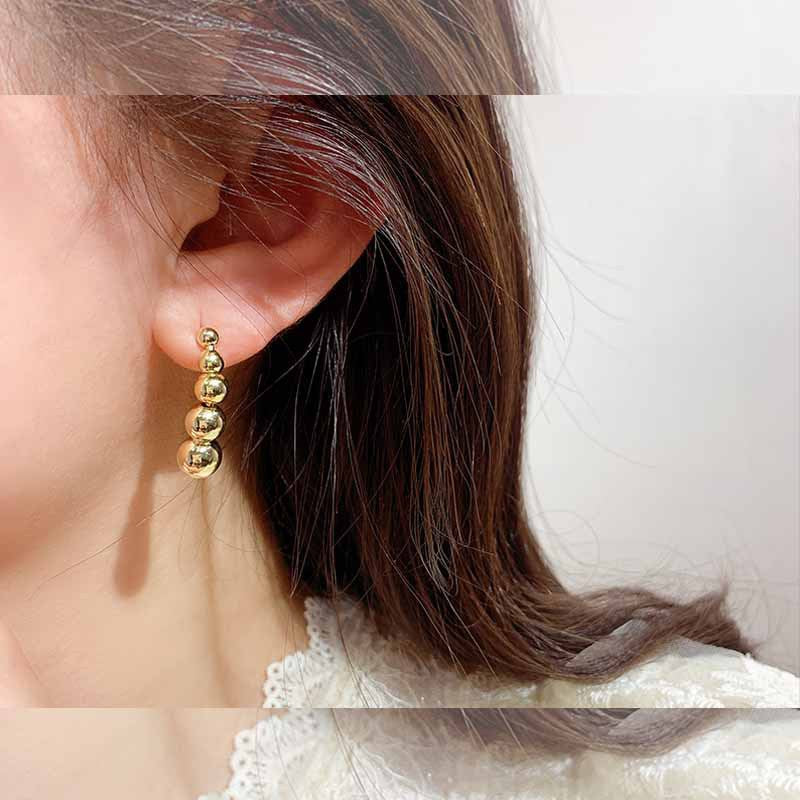 A pair of elegant small gold heart stud earrings shown against a clean background.