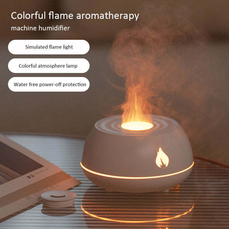 Modern white flame humidifier and essential oil diffuser glowing with a warm orange flame light on a minimalist desk.