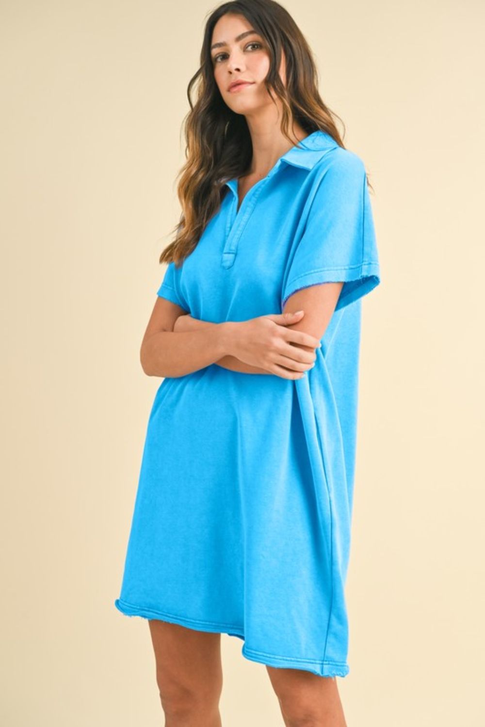 Woman wearing a sky blue short sleeve casual cotton dress with a mineral wash finish.