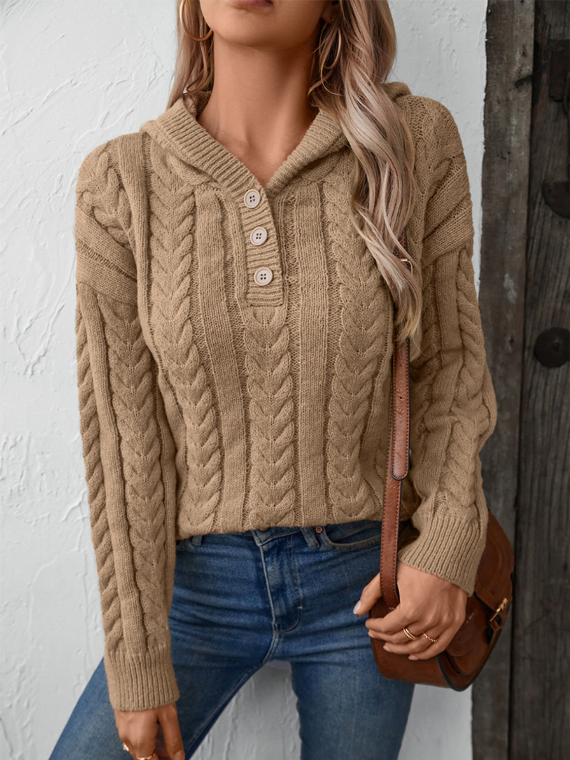 Tan cable-knit hooded sweater featuring a three-button placket and long sleeves on a model.