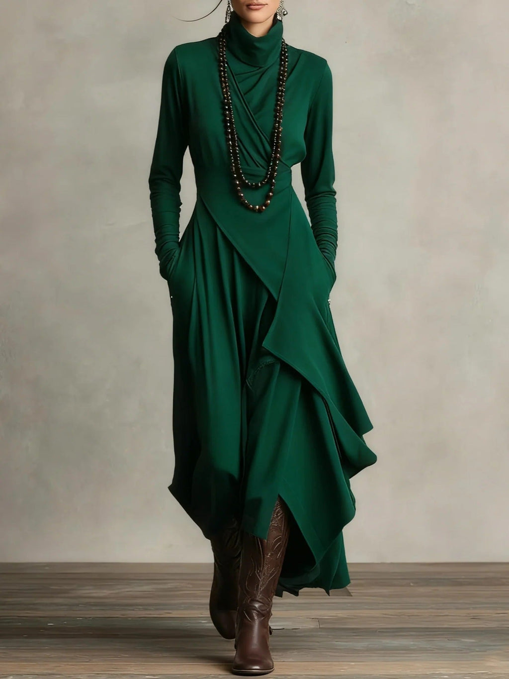 A woman wearing a long-sleeve high-neck maxi dress with a cross-wrap bodice and side pockets in forest green.