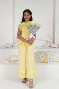 Girl wearing a pastel yellow ruffle top and long pants floral co-ord set