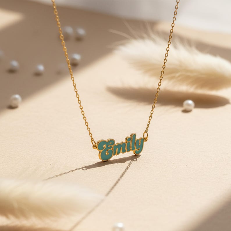 Personalized cursive name necklace available in gold, teal, pink, and magenta finish