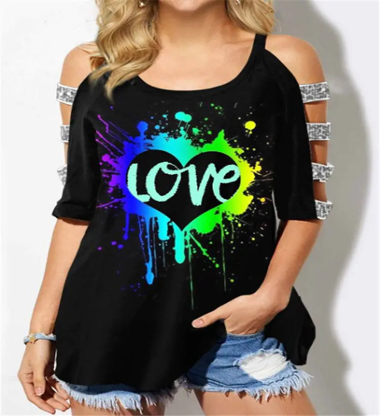 A woman wearing a black short-sleeve off-shoulder t-shirt with a colorful rainbow heart graphic and cut-out sleeve details